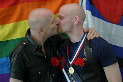 Photo of Dave and John kissing after their partnership registration. June 2003